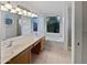 Bright bathroom with double sinks, lots of counter space, and a large garden tub under a window at 5976 W Alameda Rd, Glendale, AZ 85310