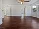 Spacious living room featuring hardwood floors, white walls, a ceiling fan, and an open doorway to other rooms at 5976 W Alameda Rd, Glendale, AZ 85310