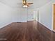 Spacious living room with hardwood floors, white walls, a ceiling fan, and an open doorway to other rooms at 5976 W Alameda Rd, Glendale, AZ 85310