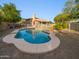 Backyard pool surrounded by desert landscaping, grass and privacy fence with a view of the house at 5976 W Alameda Rd, Glendale, AZ 85310