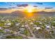 Stunning aerial view of a community featuring desert landscaping and mountain views at sunset at 6002 E Cholla Rd, Cave Creek, AZ 85331