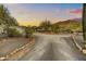 Long driveway leading to a charming home surrounded by lush desert vegetation and trees at 6002 E Cholla Rd, Cave Creek, AZ 85331