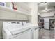 Functional laundry area with modern washer, dryer, built-in shelving, and storage space at 6055 E Hannibal St, Mesa, AZ 85205
