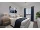 Cozy bedroom with carpet, queen bed with white and navy bedding, side tables with lamps at 6509 W Apex Ave, Queen Creek, AZ 85144
