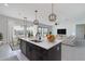 Open-concept kitchen featuring island with sink, dark wood cabinets, stainless appliances, and pendant lighting at 6509 W Apex Ave, Queen Creek, AZ 85144