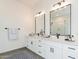 Bright bathroom featuring double sink vanity, sleek black hardware, quartz countertop, and decorative accents at 6564 W Apex Ave, Queen Creek, AZ 85144