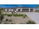 Beautiful desert home featuring a three-car garage, modern architecture, and desert landscaping at 6564 W Apex Ave, Queen Creek, AZ 85144