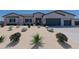 Inviting single-story home featuring desert landscaping, multiple-car garage, and neutral color palette at 6579 W Apex Ave, Queen Creek, AZ 85144