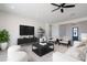 Bright living room with modern furniture, a ceiling fan, and a view to the home's entry at 6579 W Apex Ave, Queen Creek, AZ 85144