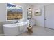 This bathroom features a modern soaking tub, a serene view, and a neutral color palette at 6604 W Apex Ave, Queen Creek, AZ 85144