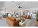 Open-concept living room with hardwood floors, a ceiling fan, and seamless access to the kitchen at 6604 W Apex Ave, Queen Creek, AZ 85144