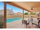Covered patio with outdoor seating, offering a view of the refreshing pool and surrounding landscape at 6901 W Tonto Dr, Glendale, AZ 85308