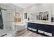 A modern bathroom boasts a soaking tub, a glass shower, double vanities, and modern fixtures at 6901 W Tonto Dr, Glendale, AZ 85308