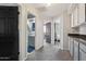 Hallway with gray carpet, doors to bathroom and bedrooms, and cabinets above a gray countertop at 6901 W Tonto Dr, Glendale, AZ 85308