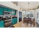A kitchen is featured with stainless appliances, turquoise cabinetry, and tiled floors in an open concept design at 6901 W Tonto Dr, Glendale, AZ 85308