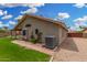 Rear exterior view of the home showcasing the yard, patio, air conditioning unit, and block wall at 7344 E Lindner Cir, Mesa, AZ 85209
