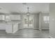 Dining area featuring stylish lighting fixtures, adjacent to the modern kitchen and new laminate flooring at 7345 W Beryl Ave, Peoria, AZ 85345