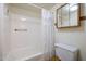A clean bathroom featuring a bathtub and shower combination, toilet, and wood medicine cabinet at 8329 E Keim Dr, Scottsdale, AZ 85250