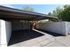 A covered carport with a concrete surface, features a privacy wall and ample parking space at 8329 E Keim Dr, Scottsdale, AZ 85250
