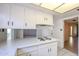 Kitchen features white cabinets, cooktop, and open view into an additional living area at 8329 E Keim Dr, Scottsdale, AZ 85250
