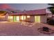Inviting backyard with a covered patio, gravel landscaping, and a cozy fire pit area at 9009 E Sahuaro Dr, Scottsdale, AZ 85260