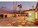 Desert landscaped backyard with a covered patio and towering palm trees at 9009 E Sahuaro Dr, Scottsdale, AZ 85260