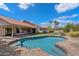 Beautiful pool with desert landscaping and covered patio adjacent to green grass and tile roof home at 10510 E Terra Dr, Scottsdale, AZ 85258