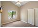 Bedroom with neutral carpet and paint, a ceiling fan, and a large window at 10510 E Terra Dr, Scottsdale, AZ 85258