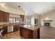 Open kitchen with granite countertops, dark wood cabinetry, and island flows to a living area with fireplace at 10510 E Terra Dr, Scottsdale, AZ 85258