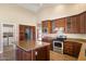 Updated kitchen featuring stainless steel appliances, custom wood cabinets, and a center island with granite countertops at 10510 E Terra Dr, Scottsdale, AZ 85258
