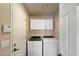 Bright laundry room with white washer, dryer, and cabinets for storage at 10510 E Terra Dr, Scottsdale, AZ 85258