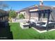 Expansive backyard featuring lush artificial turf, a fire pit area, an outdoor chess set, and comfortable seating at 10694 E Firethorn Dr, Scottsdale, AZ 85255