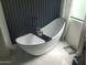 Modern bathroom featuring a sleek white soaking tub with a black faucet and stylish accents at 10694 E Firethorn Dr, Scottsdale, AZ 85255