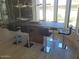 Contemporary dining area with a large table, sleek bar stools, and floor-to-ceiling windows offering ample natural light at 10694 E Firethorn Dr, Scottsdale, AZ 85255