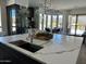 Kitchen featuring an island with quartz countertop, seating, stainless appliances, a sink, and a wine display at 10694 E Firethorn Dr, Scottsdale, AZ 85255