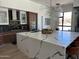 Modern kitchen island with quartz countertop and seating, complemented by stainless steel appliances and sleek cabinets at 10694 E Firethorn Dr, Scottsdale, AZ 85255