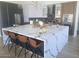 Modern kitchen island with quartz countertop and seating, complemented by stainless steel appliances and stylish lighting at 10694 E Firethorn Dr, Scottsdale, AZ 85255