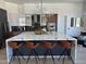 Modern kitchen featuring an island with quartz countertop and seating, stainless steel appliances, and unique light fixtures at 10694 E Firethorn Dr, Scottsdale, AZ 85255
