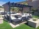 Inviting covered outdoor area with stylish seating, a pergola, and well manicured turf at 10694 E Firethorn Dr, Scottsdale, AZ 85255
