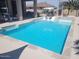 Beautiful pool with a tanning ledge, surrounded by lush landscaping, offering a relaxing outdoor oasis at 10694 E Firethorn Dr, Scottsdale, AZ 85255