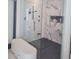 Walk-in shower featuring black fixtures, marble wall, and bench at 10694 E Firethorn Dr, Scottsdale, AZ 85255