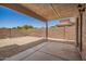 Backyard space with a covered patio and a gravel area, surrounded by a tall brick wall at 11004 E Delta Ave, Mesa, AZ 85208