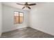 Bright bedroom features a ceiling fan, wood-look floors, fresh white walls and a window with a view at 11004 E Delta Ave, Mesa, AZ 85208