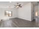 Bright, open living room features gray wood flooring and a modern ceiling fan at 11004 E Delta Ave, Mesa, AZ 85208