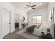 Bedroom features a ceiling fan, large window, neutral decor, and a view to the ensuite bathroom at 11004 E Delta Ave, Mesa, AZ 85208