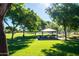 A community park offering lush lawns, mature trees, and covered picnic areas, perfect for outdoor recreation and relaxation at 11004 E Delta Ave, Mesa, AZ 85208