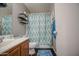Bathroom featuring a sink, toilet with a blue and green shower curtain, and a towel at 11301 W Glenrosa Ave, Phoenix, AZ 85037
