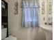 Cozy bathroom featuring a pedestal sink, decorative accents, and blue patterned curtains at 11301 W Glenrosa Ave, Phoenix, AZ 85037
