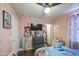 Bedroom with hardwood floors, a ceiling fan, and various decorations on the pink walls at 11301 W Glenrosa Ave, Phoenix, AZ 85037