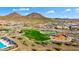 Stunning aerial view showcases community amenities including a playground, pool, and green spaces, with mountain views at 13384 W Red Range Way, Peoria, AZ 85383